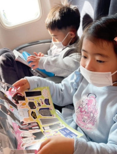 飛行機で移動する子どもたちの写真